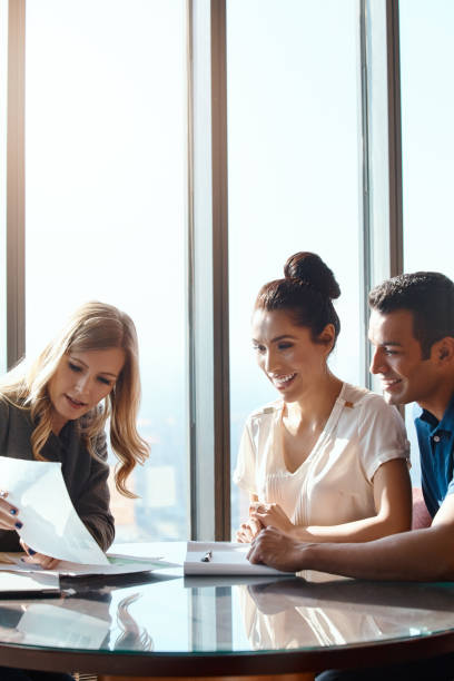Shot of a young couple meeting with a financial planner in a modern office
